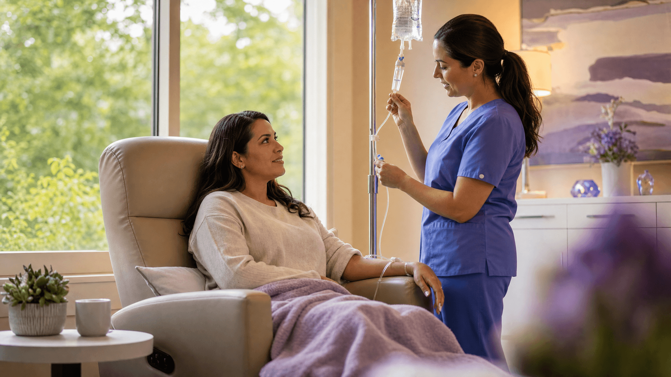 A patient relaxing in an infusion chair while a nurse adjusts her IV drip